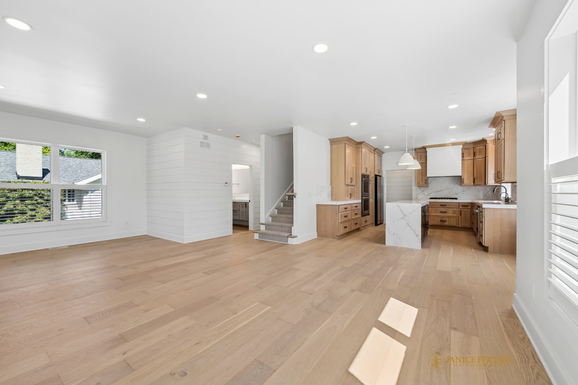 Open-plan custom home interior with a light wood kitchen and wide plank flooring
