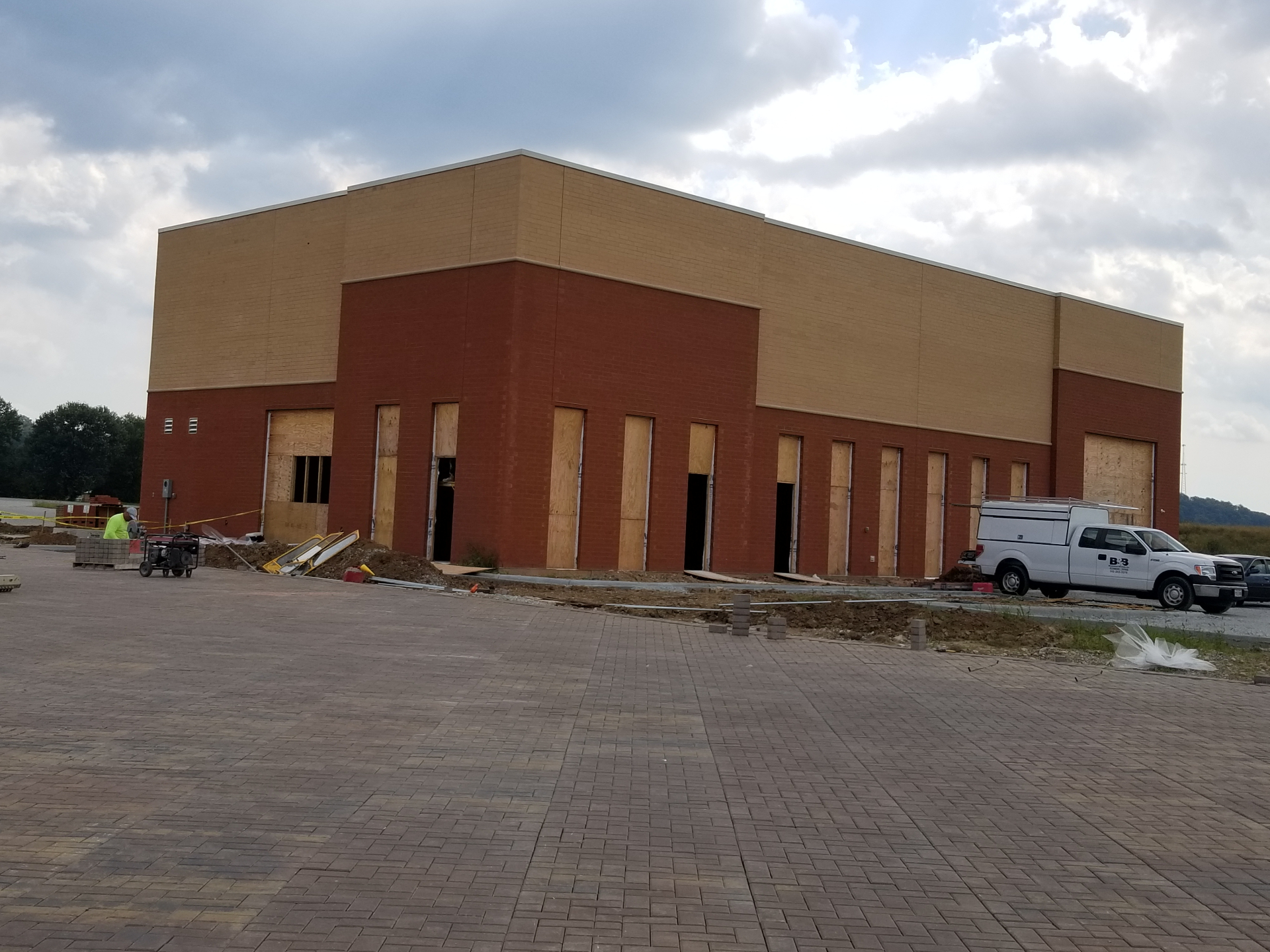 Brick and tan commercial building with paver lot during final construction