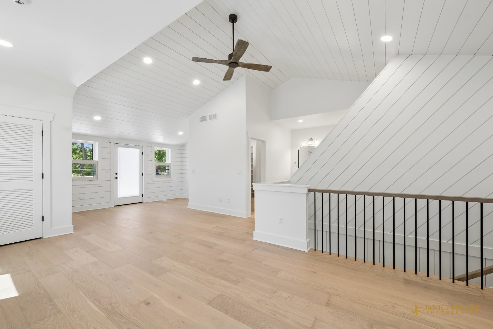 Bright, open-concept M3 Builders home interior with a vaulted shiplap ceiling, light wood floors, and a staircase landing